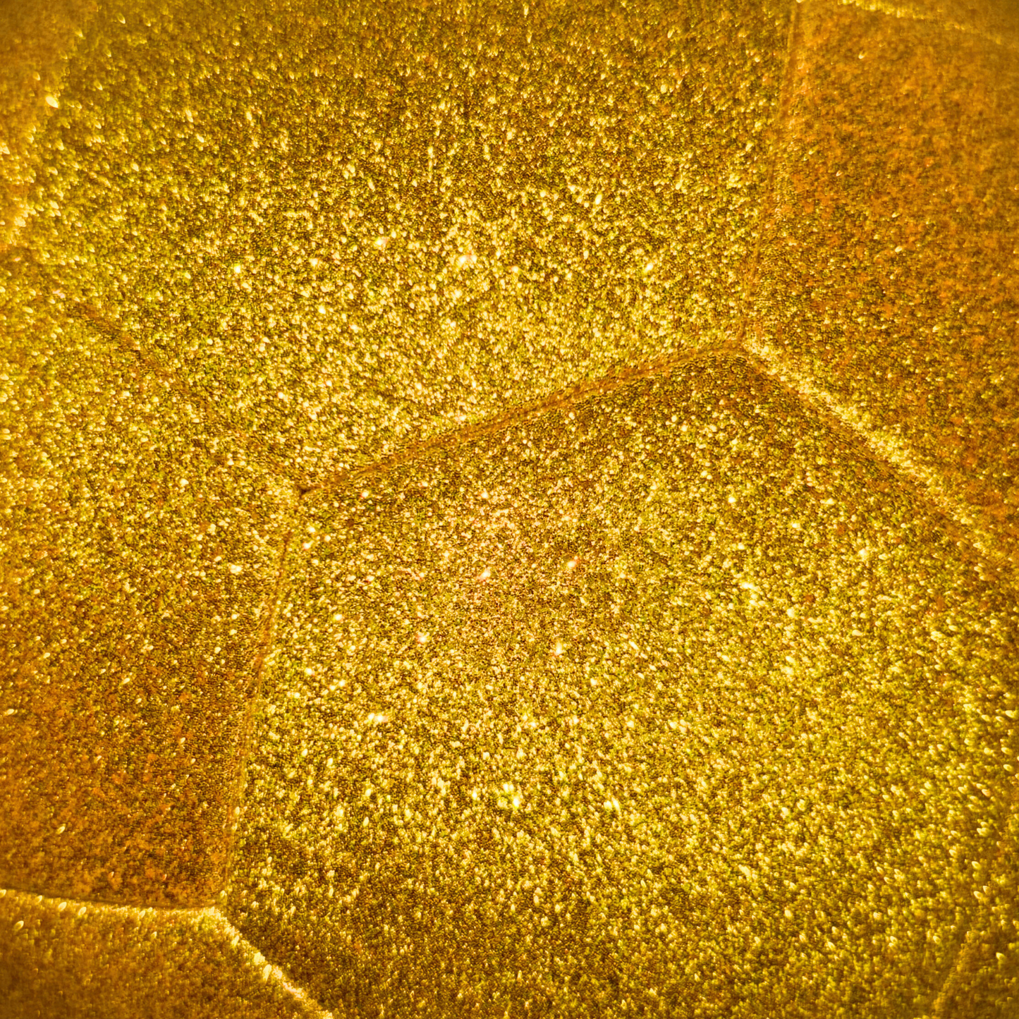 Closeup photo of kids gold glitter soccer ball sparkle and texture.