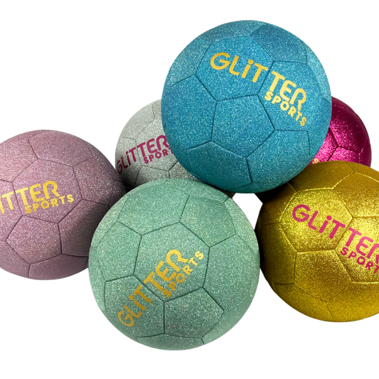 A pile of colourful glittery soccer balls in blue, pastel pink, green, gold and bright pink with gold and pink 'Glitter Sports' logos on transparent background.