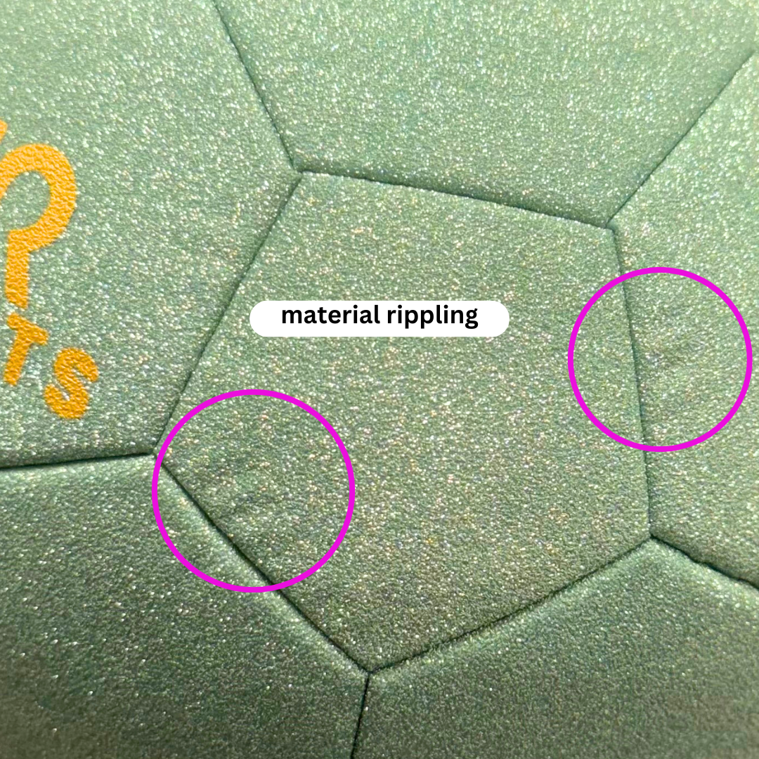 Close up of size 3 green glitter soccer ball exterior showing minor rippling in exterior identified with pink circles and a note reading 'material rippling'.