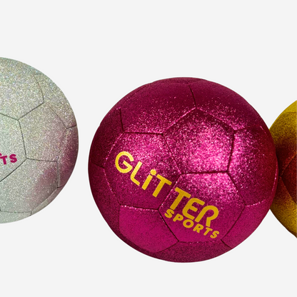 Bright pink kids glitter soccer ball with gold 'Glitter Sports' logo next to partial view of gold and silver versions on white background.