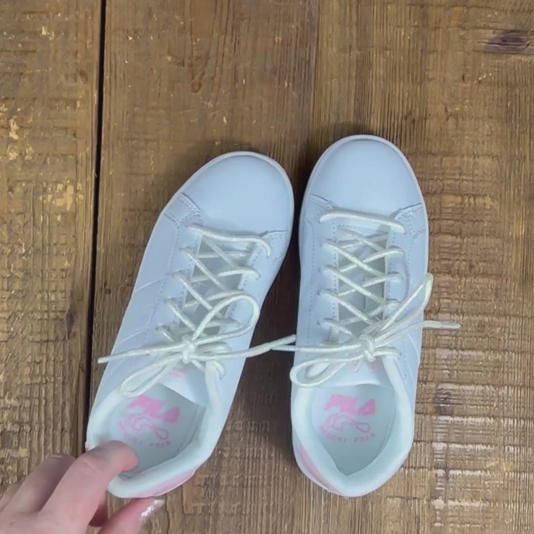 Two white and pink Fila sneakers with white pearl fairy shoelaces. One held up to camera to show pearlescent and holographic shimmer effect.